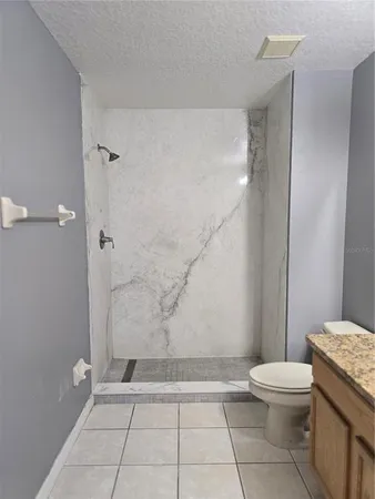a bathroom with a granite countertop bathtub and toilet