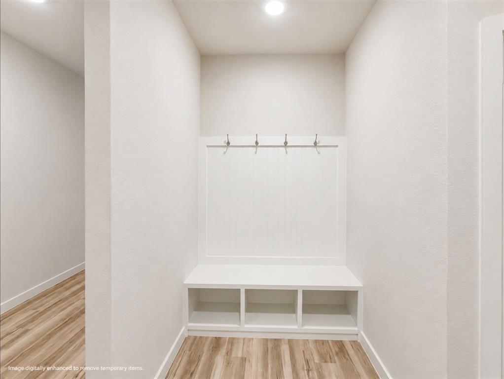 631 Cari Lane Forney, TX 75126 - Photo 13 of 17 Built-in bench with storage cubbies, wainscoting paneling, and four wall-mounted hooks