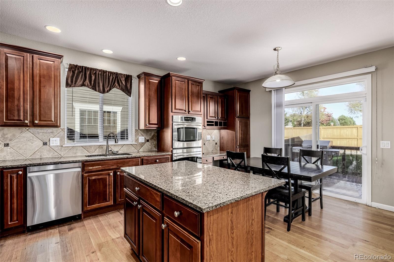 139 Muscovey Lane Johnstown, CO 80534 - Photo 12 of 49 a kitchen with a stove sink cabinets and wooden floor