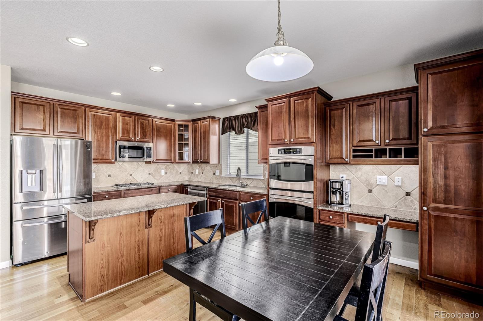 139 Muscovey Lane Johnstown, CO 80534 - Photo 14 of 49 a kitchen with a refrigerator a stove a sink a dining table and chairs
