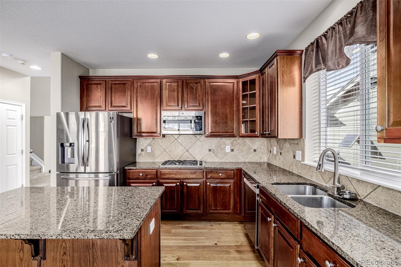 139 Muscovey Lane Johnstown, CO 80534 - Photo 15 of 49 a kitchen with stainless steel appliances granite countertop a sink stove and refrigerator