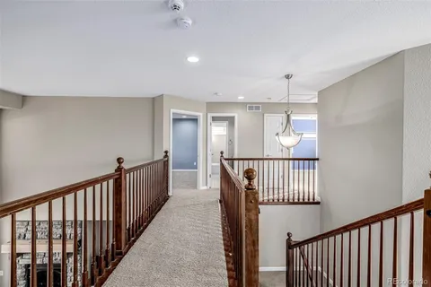 a view of a hallway with wooden floor and windows