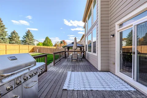 a view of a patio with table and chairs with wooden floor and fence