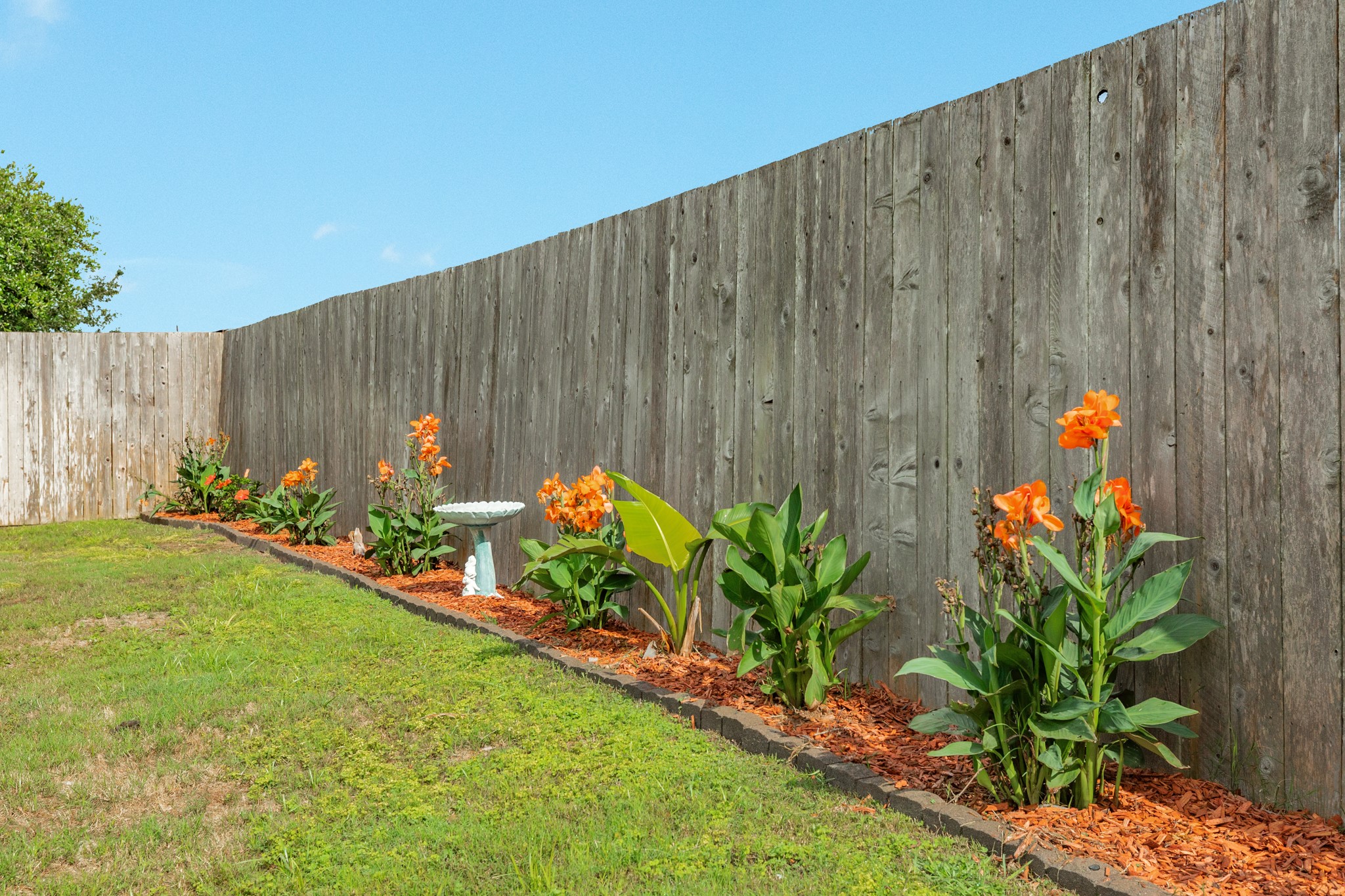 3519 Bay Drive Rosharon, TX 77583 - Photo 28 of 49 Stunning landscaping featuring vibrant, blooming flowers that enhance the peaceful ambiance of this backyard oasis.