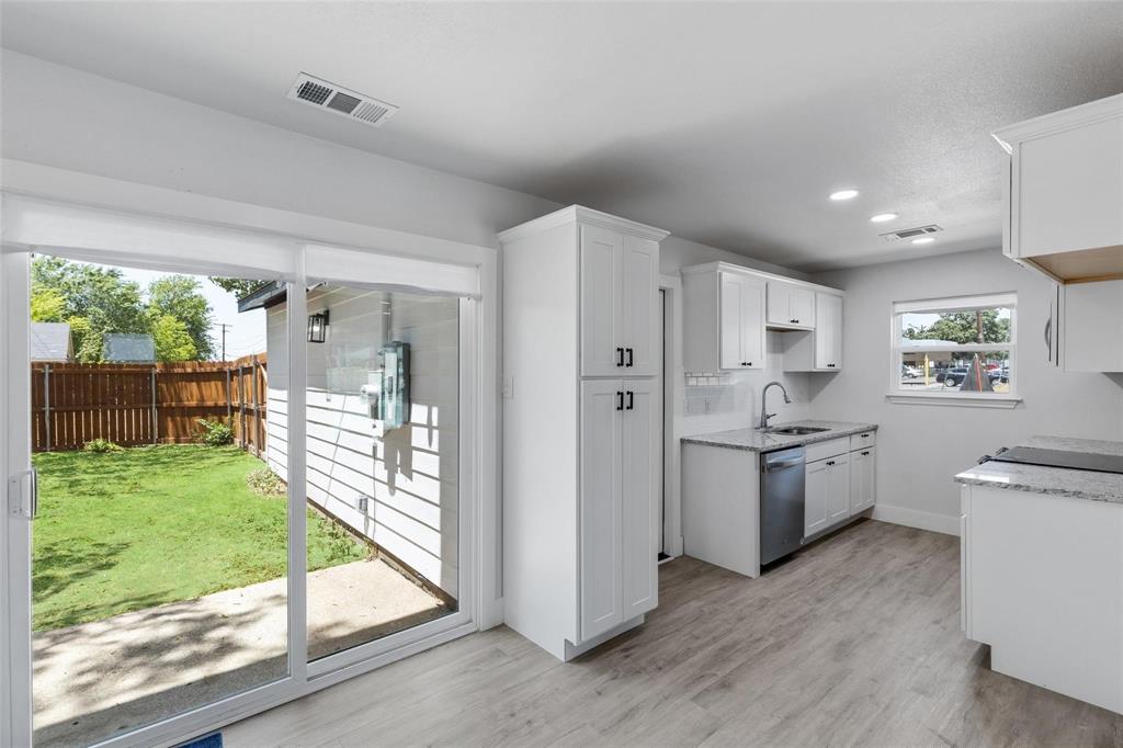 a kitchen with white cabinets and a wooden floor