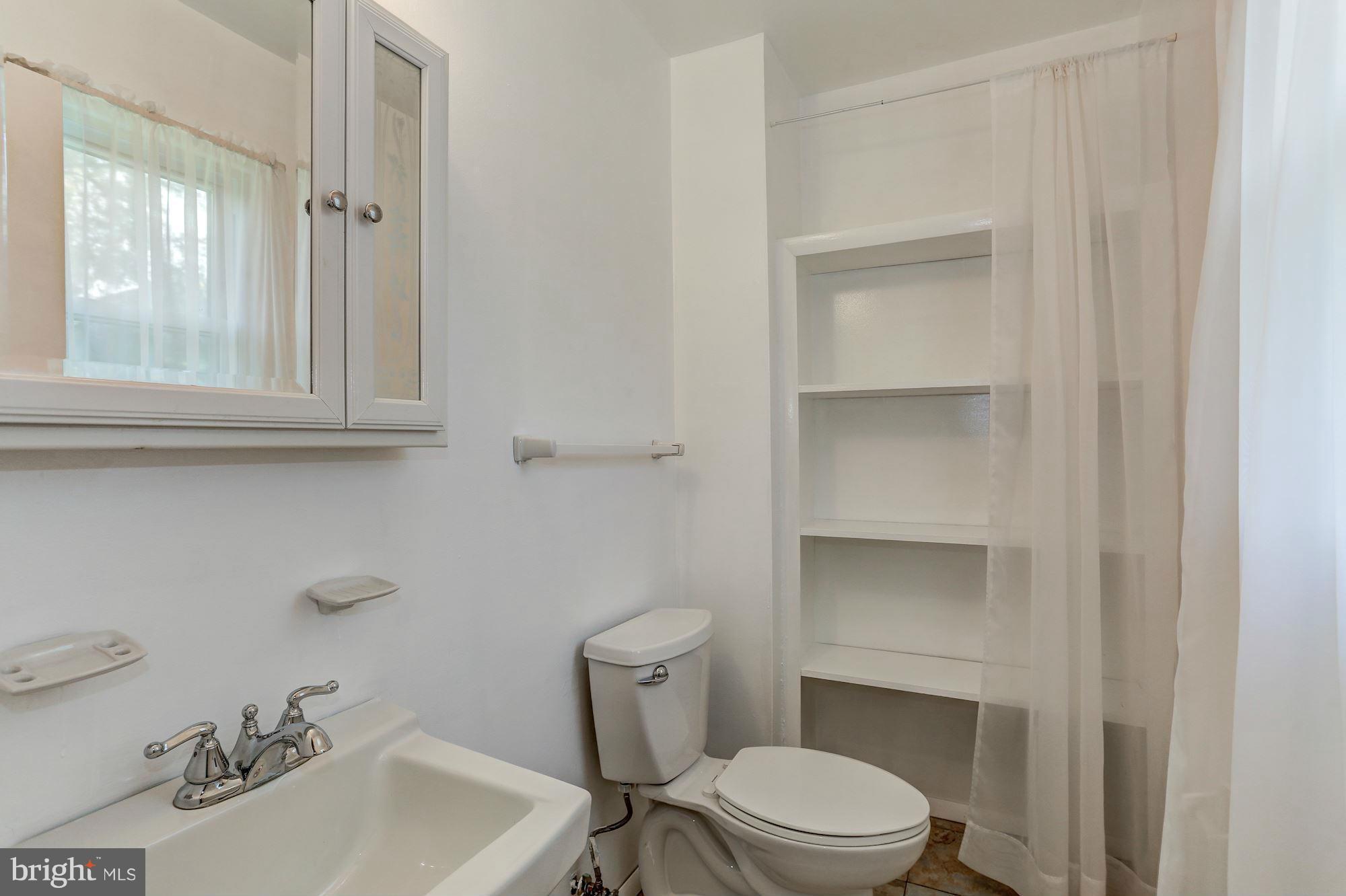 13818 Gilbert Road Woodbridge, VA 22193 - Photo 19 of 30 a bathroom with a sink a toilet and a mirror