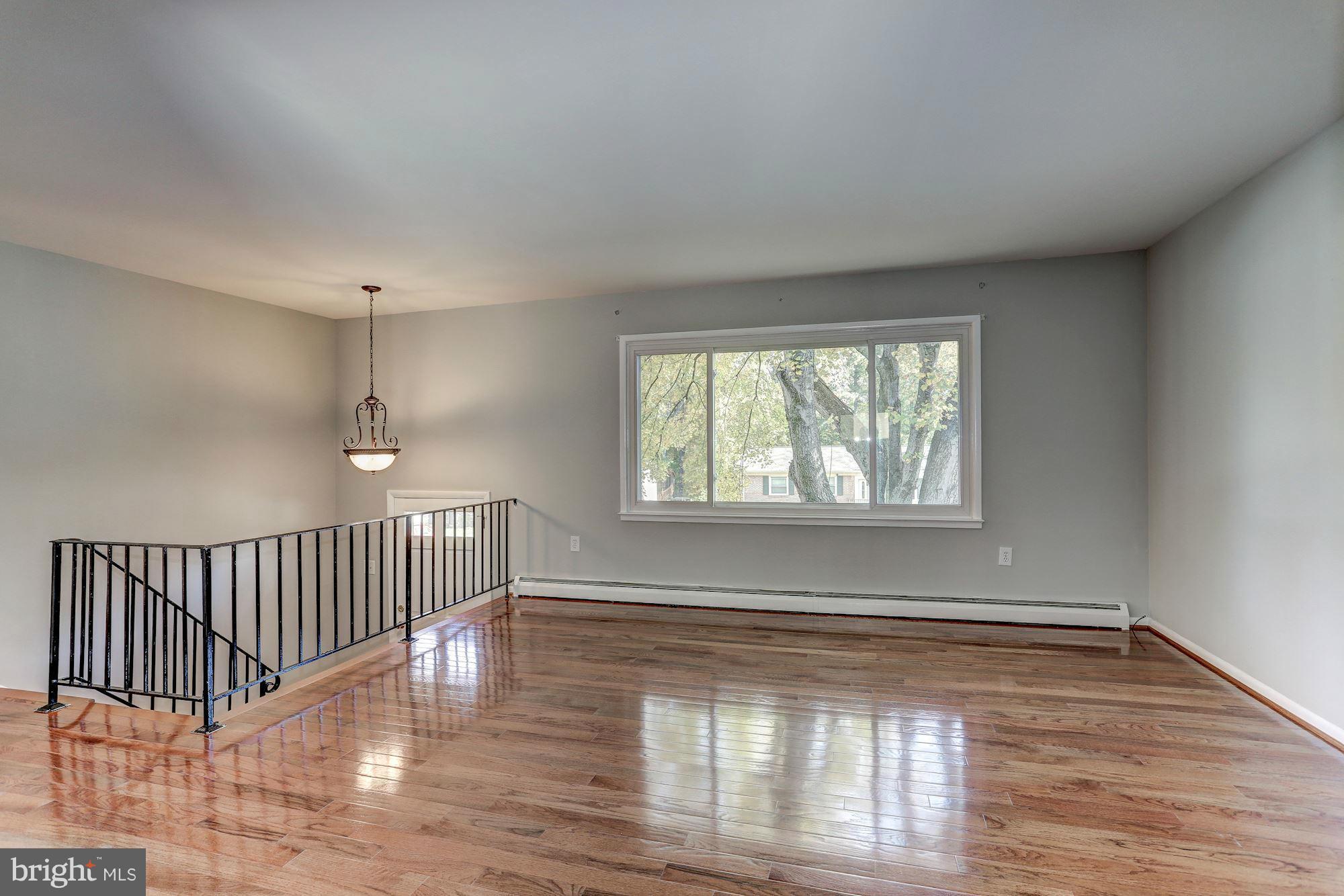 13818 Gilbert Road Woodbridge, VA 22193 - Photo 5 of 30 a view of an empty room with wooden floor and a window