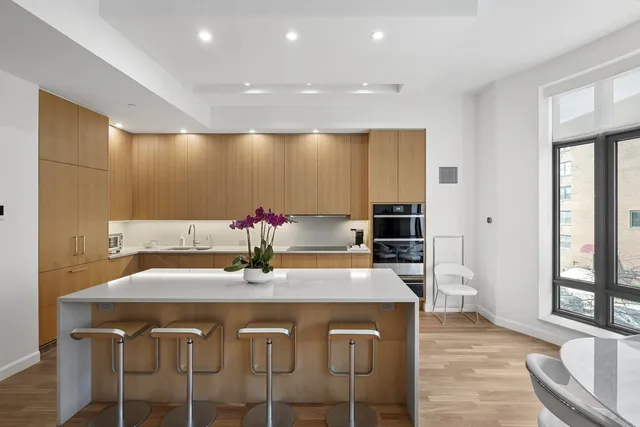 a kitchen with granite countertop a dining table chairs and white cabinets