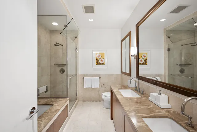 a bathroom with a granite countertop tub sink and mirror