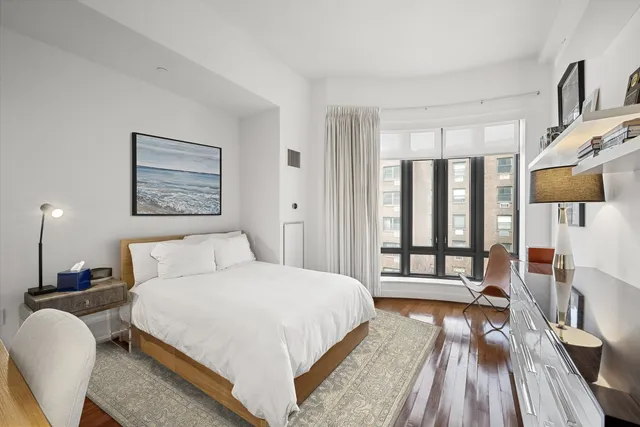 a bedroom with a large bed and a wooden floor