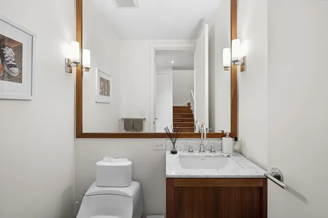 a bathroom with a toilet sink and mirror