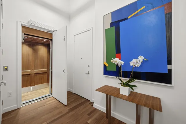 a room with painting on the wall and a potted plant