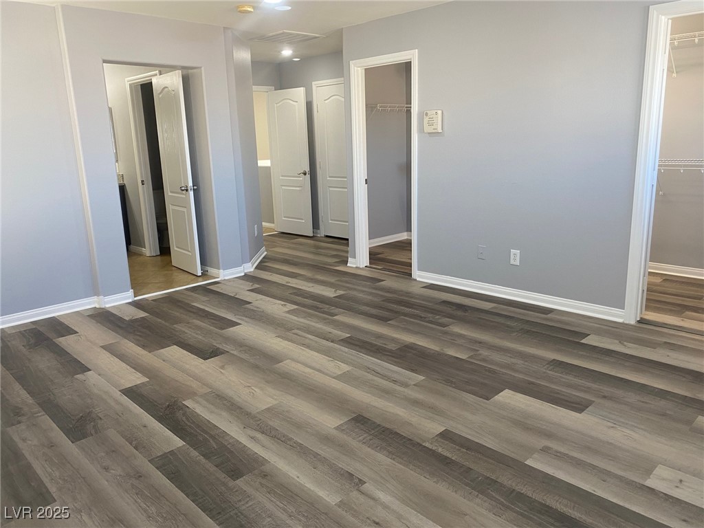 9541 Vast Valley Avenue Las Vegas, NV 89148 - Photo 15 of 32 Unfurnished bedroom with a spacious closet and dark wood-style floors