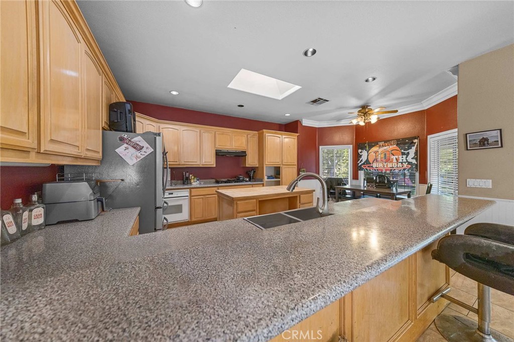 32245 Refa Street Wildomar, CA 92595 - Photo 11 of 35 a large kitchen with stainless steel appliances a large counter top a stove and a sink