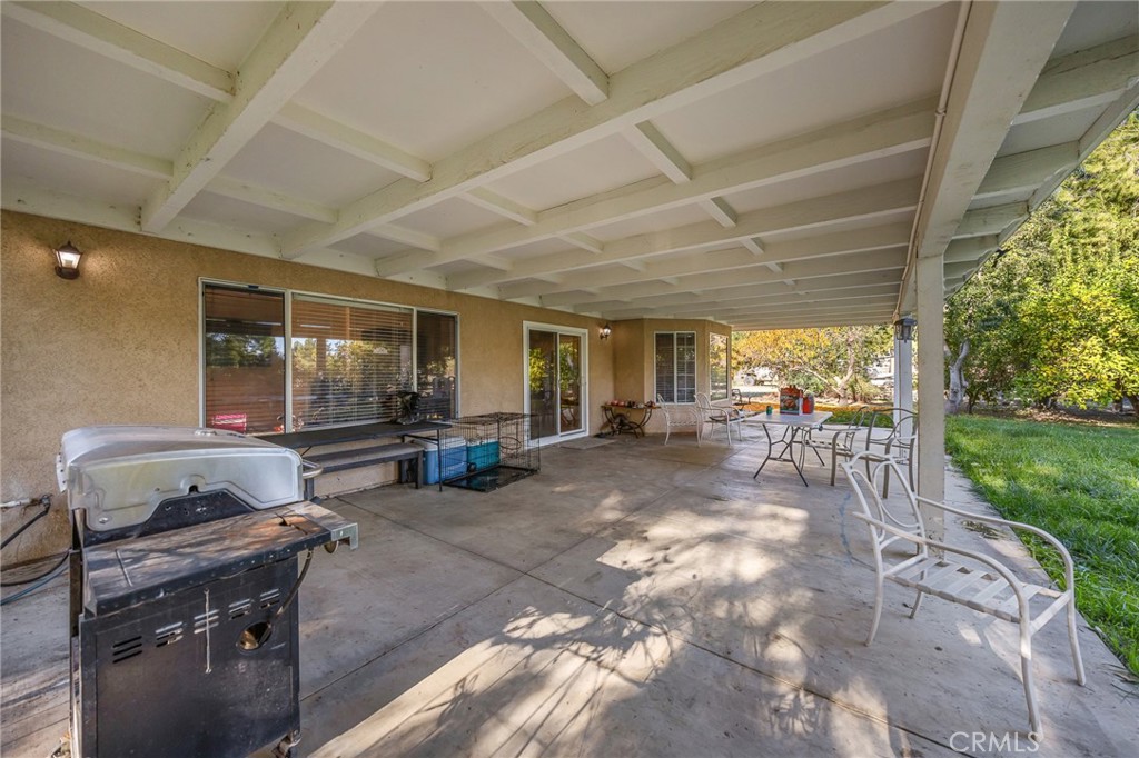 32245 Refa Street Wildomar, CA 92595 - Photo 20 of 35 a view of a patio with table and chairs a barbeque with wooden fence