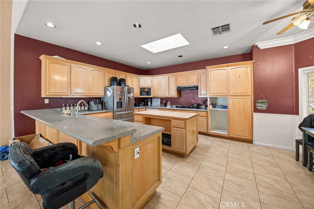 32245 Refa Street Wildomar, CA 92595 - Photo 10 of 35 a kitchen with stainless steel appliances granite countertop a sink counter space cabinets and a view of living room