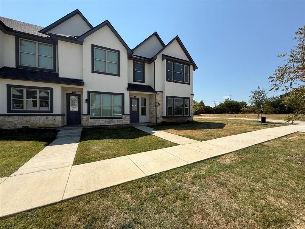 373 Buck Ridge Drive Frisco, TX 75068 - Photo 2 of 24 Contemporary architectural design with white siding and dark trim, stone veneer accents, and multiple windows