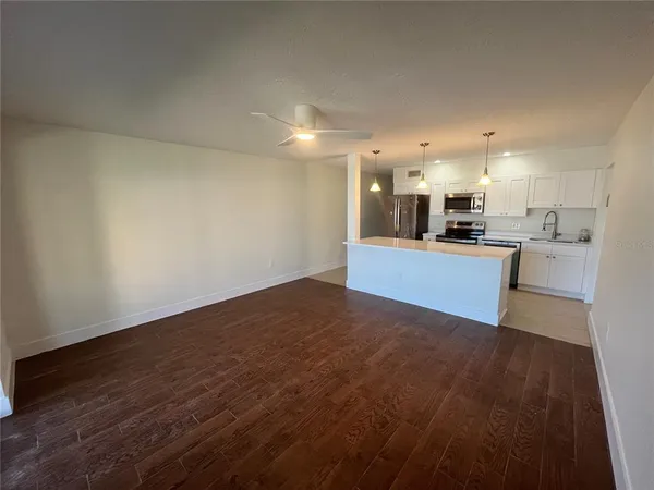 a view of a kitchen with cabinets and wooden floor