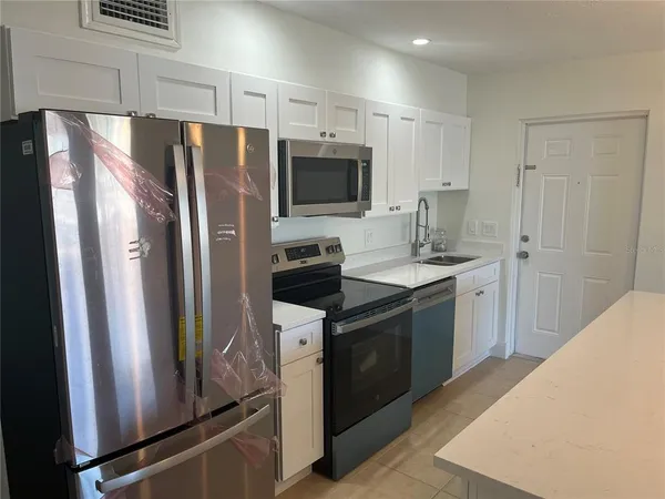 a kitchen with stainless steel appliances a refrigerator stove and sink