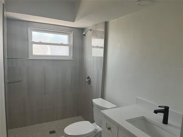 a bathroom with a sink toilet and shower