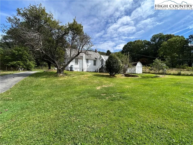a view of a big yard with large trees