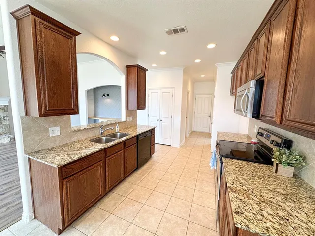 a large kitchen with stainless steel appliances granite countertop a sink stove and cabinets