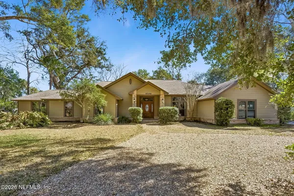 a front view of a house with a yard covered with trees