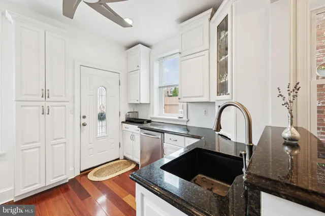 a kitchen with granite countertop a sink and cabinets