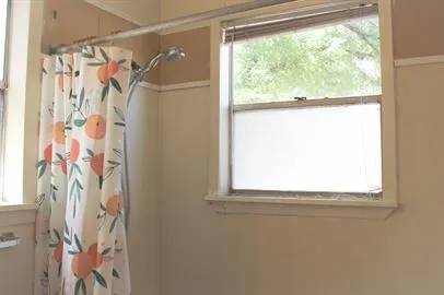 a bathroom with a window and a shower