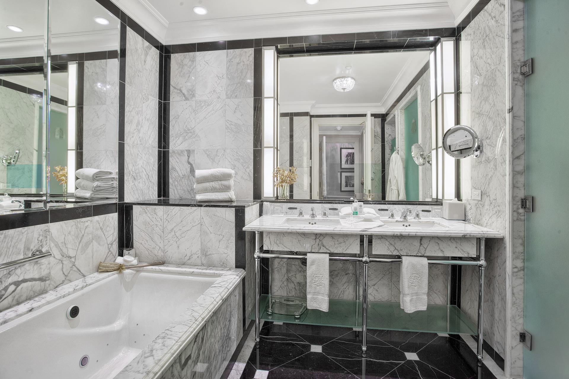 2 East 55th Street, Unit 901 Manhattan, NY 10022 - Photo 3 of 11 a bathroom with a tub sink and mirror