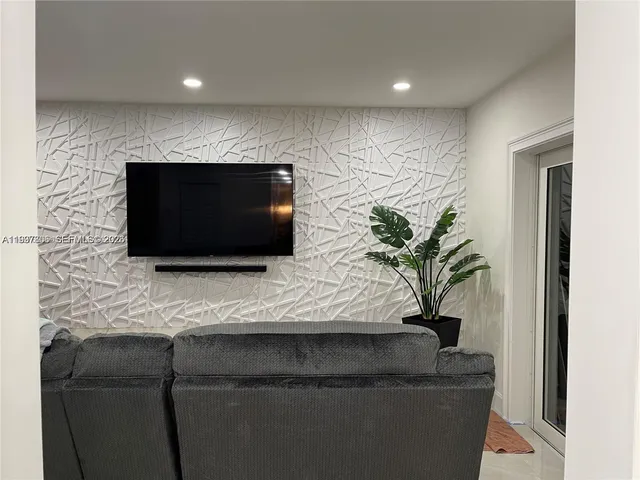 a living room with a flat screen tv a potted plant and a fireplace