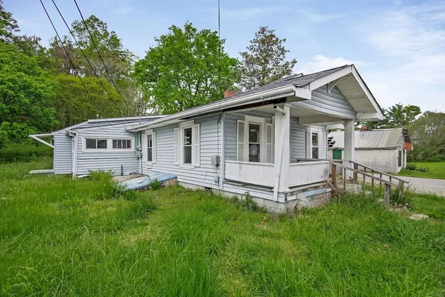 a view of a house with a yard and sitting area