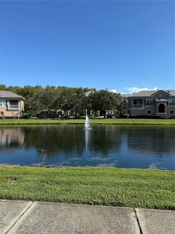 a view of a lake in front of building and trees