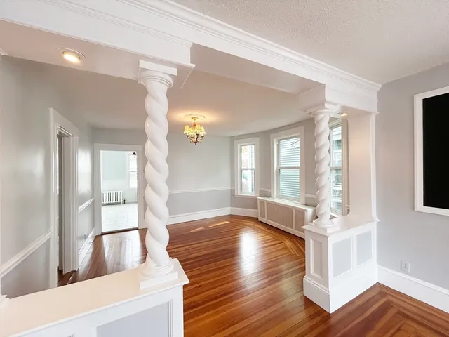 a spacious bedroom with a bed and wooden floor