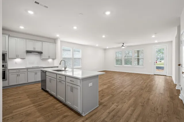 a kitchen with stainless steel appliances granite countertop a sink stove and cabinets
