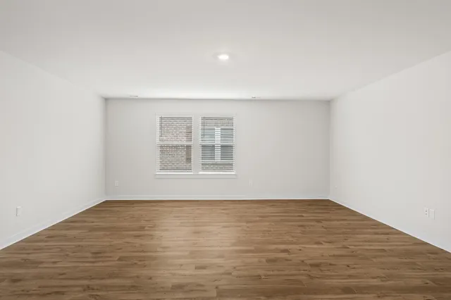 a view of an empty room and wooden floor