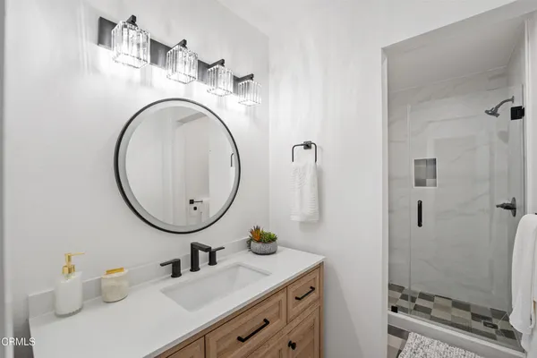 a bathroom with a sink a mirror and a shower