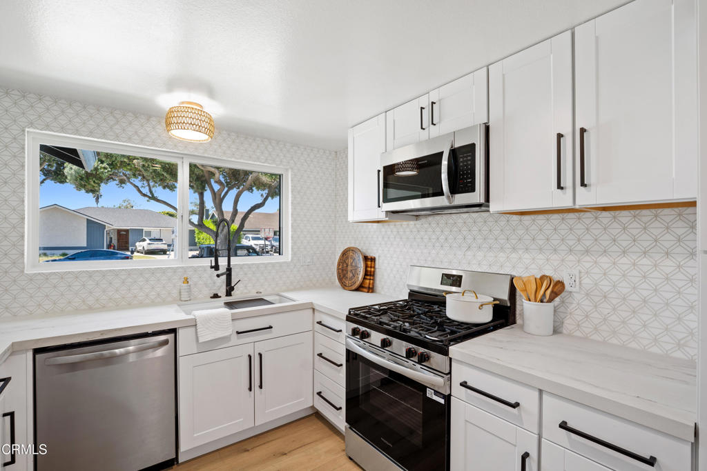 930 Topsail Court Oxnard, CA 93035 - Photo 3 of 31 a kitchen with stainless steel appliances white cabinets and a stove top oven