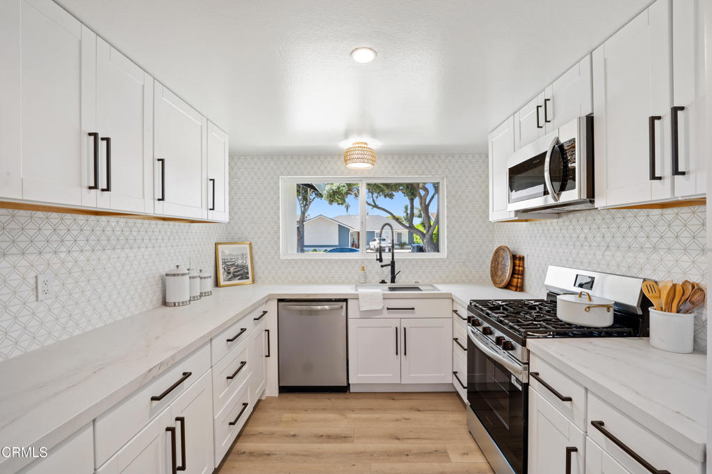 930 Topsail Court Oxnard, CA 93035 - Photo 5 of 31 a kitchen with stainless steel appliances a sink stove top oven and cabinets