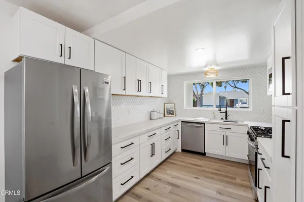 a kitchen with white cabinets and stainless steel appliances
