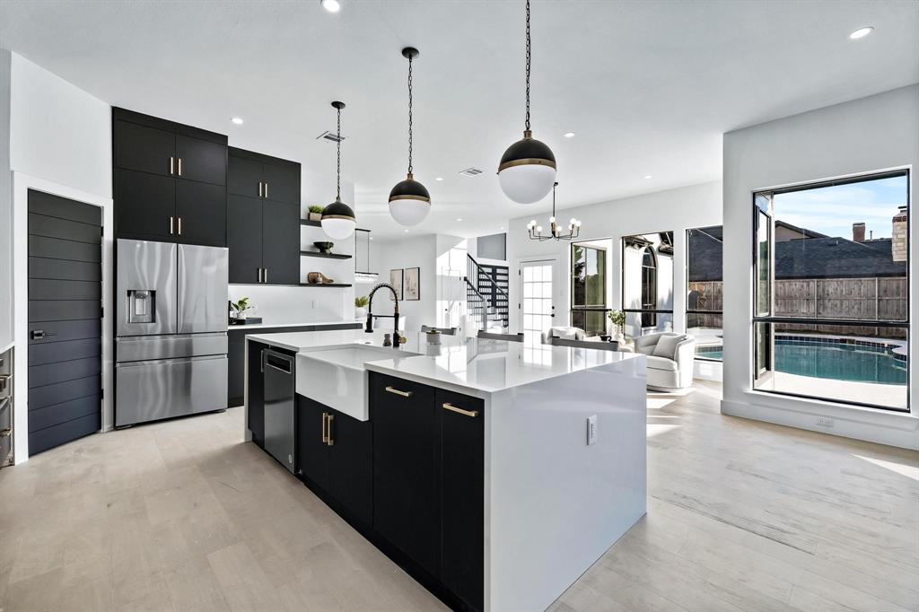a kitchen with stainless steel appliances kitchen island granite countertop a sink a stove and a refrigerator