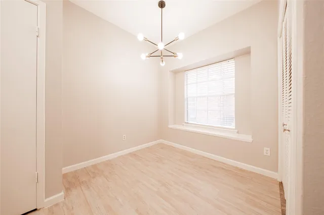 an empty room with a window and a ceiling fan