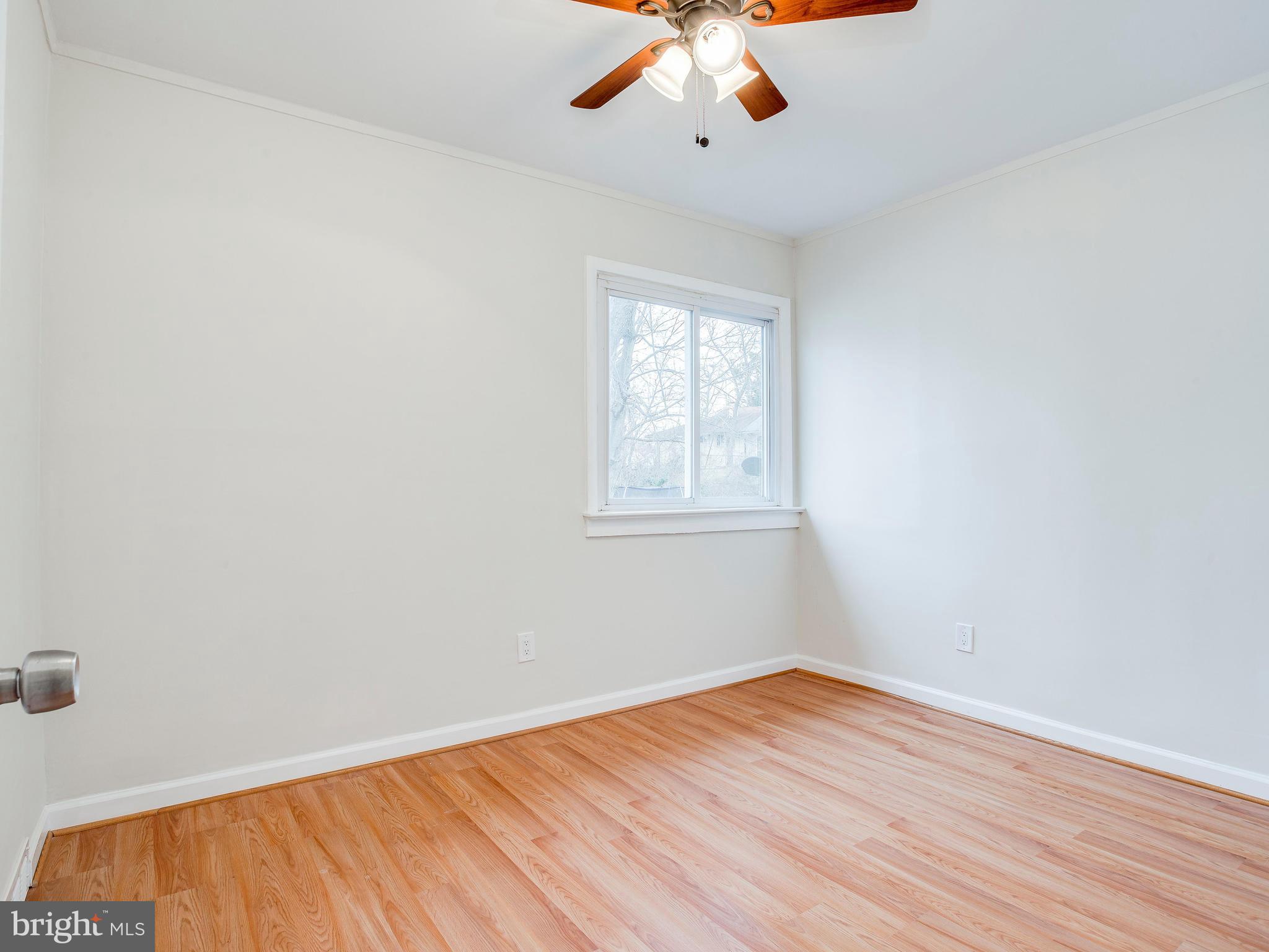 7724 Oxman Road Landover, MD 20785 - Photo 14 of 19 an empty room with wooden floor chandelier fan and windows