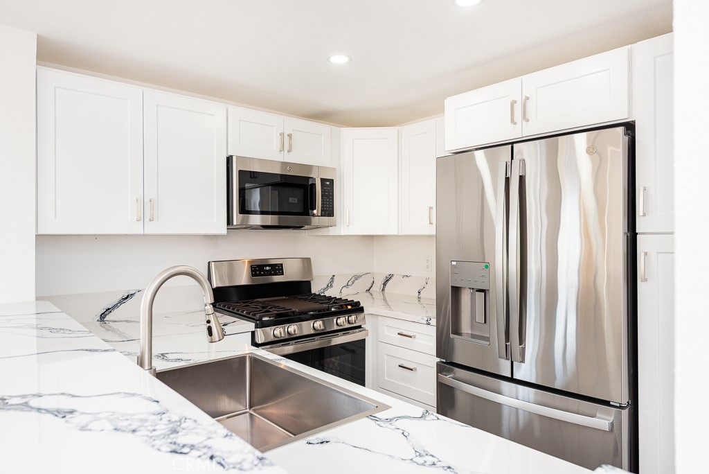 4240 Lost Hills Road, Unit 3108 Calabasas, CA 91301 - Photo 10 of 28 a kitchen with stainless steel appliances granite countertop a refrigerator stove and sink