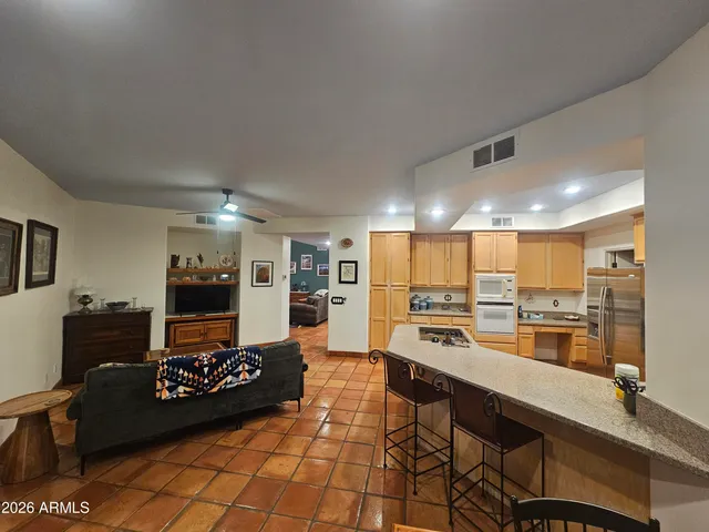 a large dining hall with stainless steel appliances granite countertop a stove and a sink