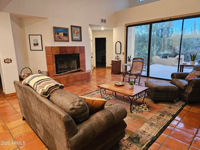 a living room with furniture large window and a fireplace