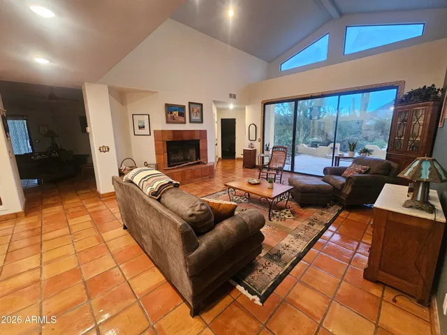 a living room with fireplace furniture and a floor to ceiling window