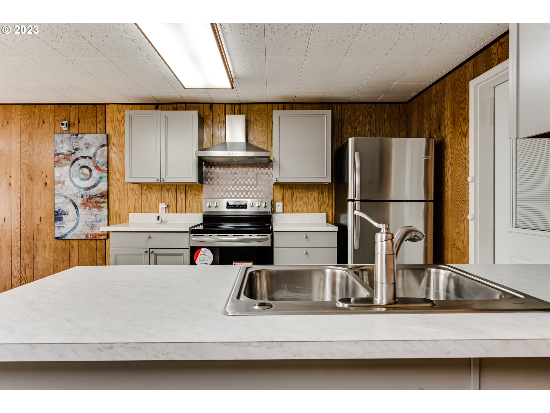 88240 Millican Road Springfield, OR 97478 - Photo 5 of 15 a kitchen with kitchen island a stove and a white refrigerator with wooden floor