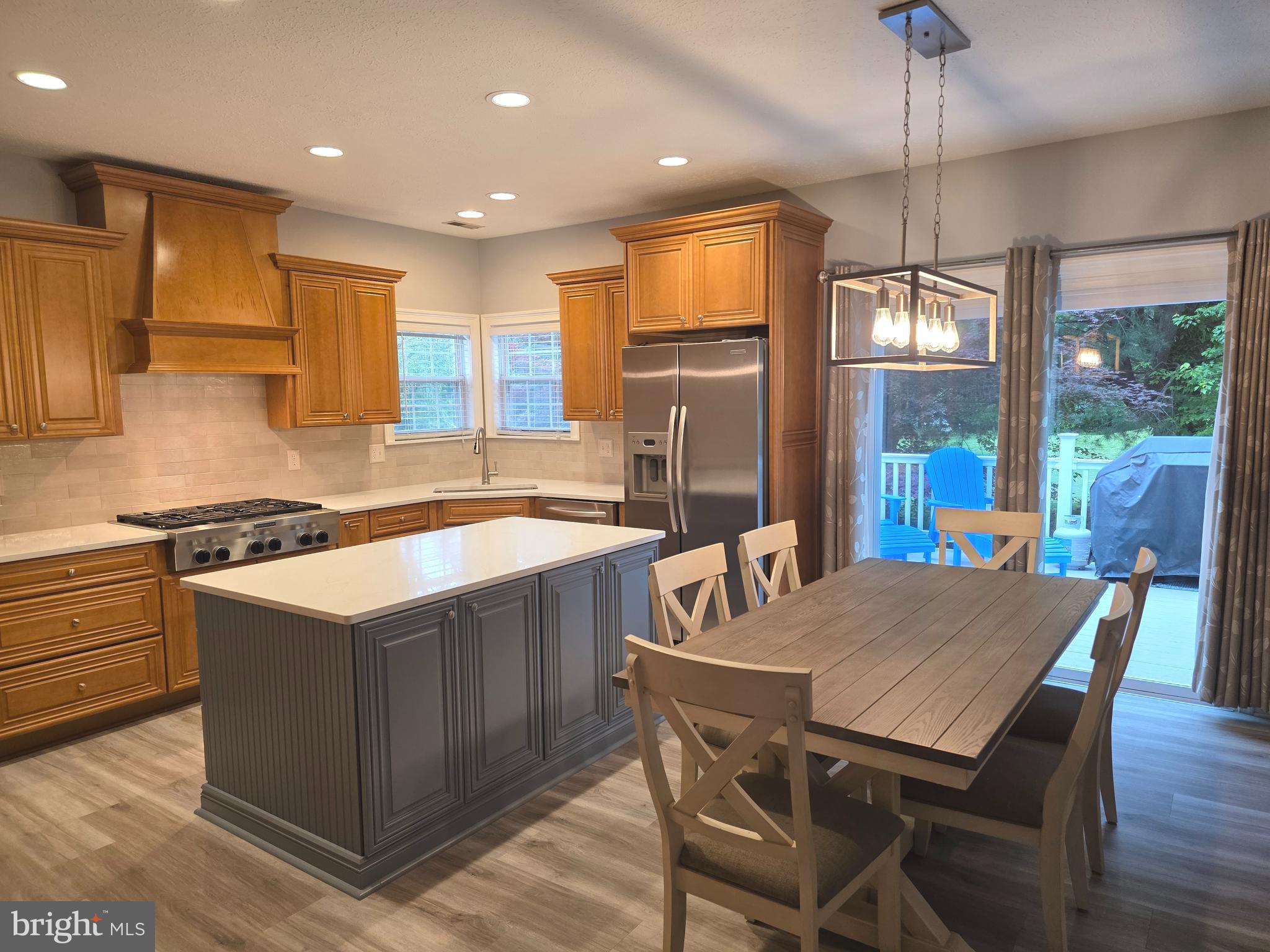 2441 Kemper Road Crofton, MD 21114 - Photo 11 of 63 a kitchen with a stove a refrigerator a sink dining table and chairs