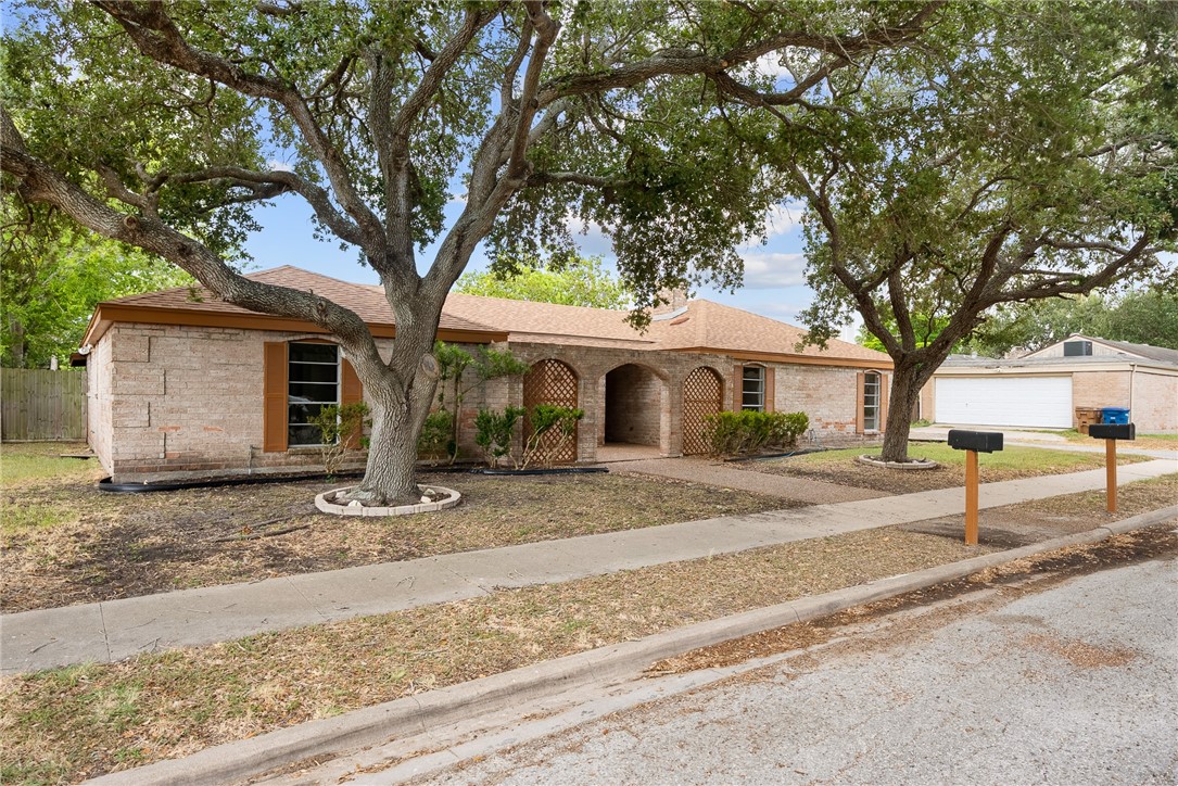a front view of a house with a tree